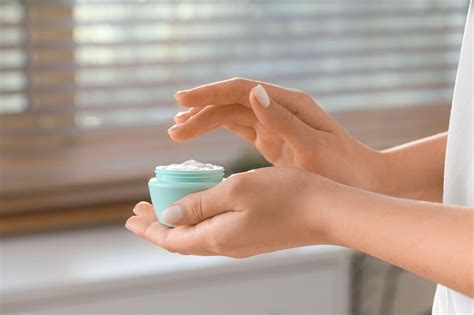Ženska, ki nanaša samoporjavitveno kremo na roko