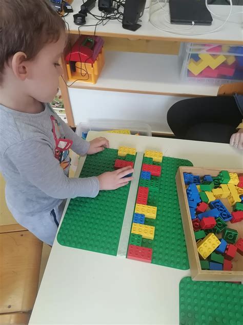 Otrok oblečen v kostum lego kocke iz kartona