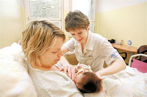 Sestra pomaga mamici pri dojenju