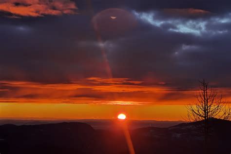 Slika para, ki se objema in gleda v sončni vzhod