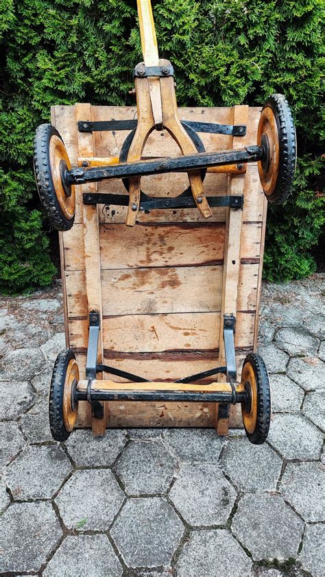 Otrok vozi leseni voziček po vrtu