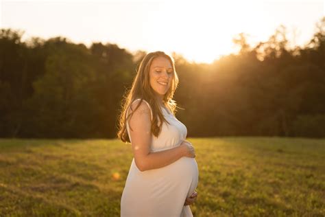 Ženska roka nežno objema nosečniško dojko