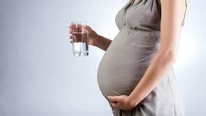 Nosečnica pije vodo iz stekleničke