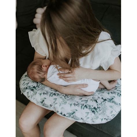 Ženska z dojenčkom, ki uporablja blazino za dojenje