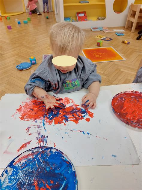 Dojenček riše s prstnimi barvami