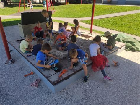 Otrok se igra z dinozavrovo kanglico in lopatko v peskovniku