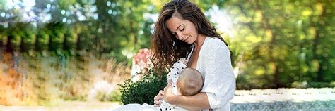 Ženska v udobni obleki za dojenje, ki se sprehaja po parku