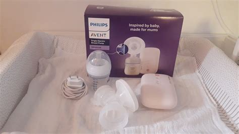 Mlada mama uporablja električno prsno črpalko