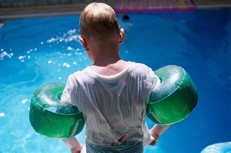 Otrok z veseljem nosi pisane plavalne rokavčke