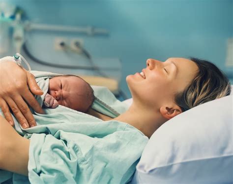 Mamica, ki drži svojega novorojenčka takoj po porodu