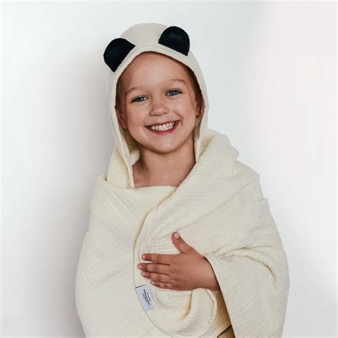 Dojenček se kopa v banji, obdan z mehko bambusovo brisačo s kapuco