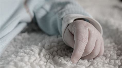 Novorojenček na tehtnici med prvim pregledom