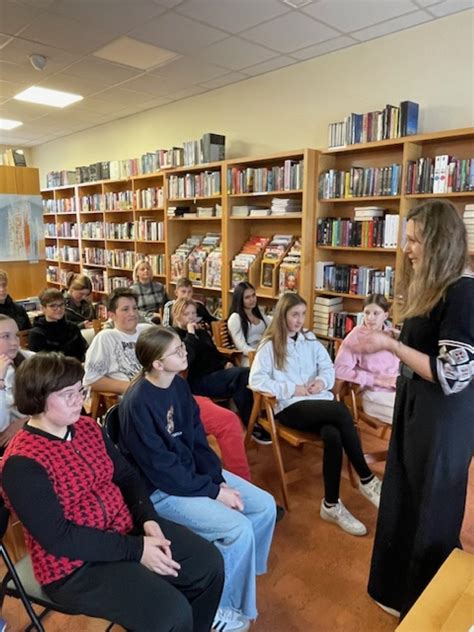 Nosečnica, ki uživa v senci s knjigo in pijačo.