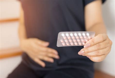 Ilustracija ženske, ki drži škatlico kontracepcijskih tabletk