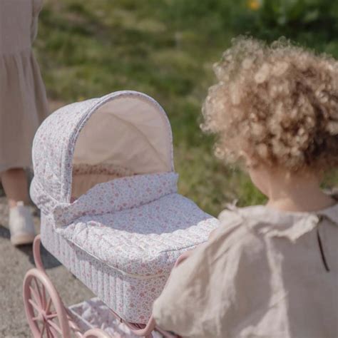 Deklica potiska voziček za punčko