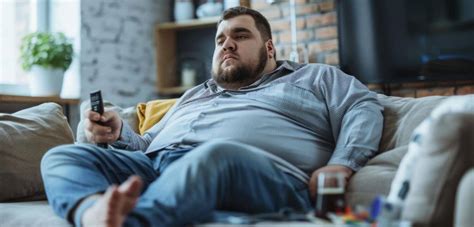 moški, ki sedi v temi in gleda televizijo