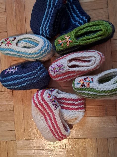 Ilustracija ženskih rok, ki držijo majhne otroške copatke