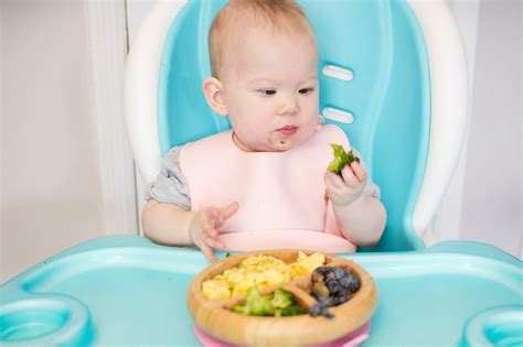 Dojenček, ki veselo packa s hrano
