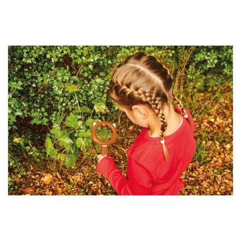 Otrok z očali, ki gleda skozi povečevalno steklo