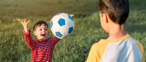otroci igrajo z žogo na prostem